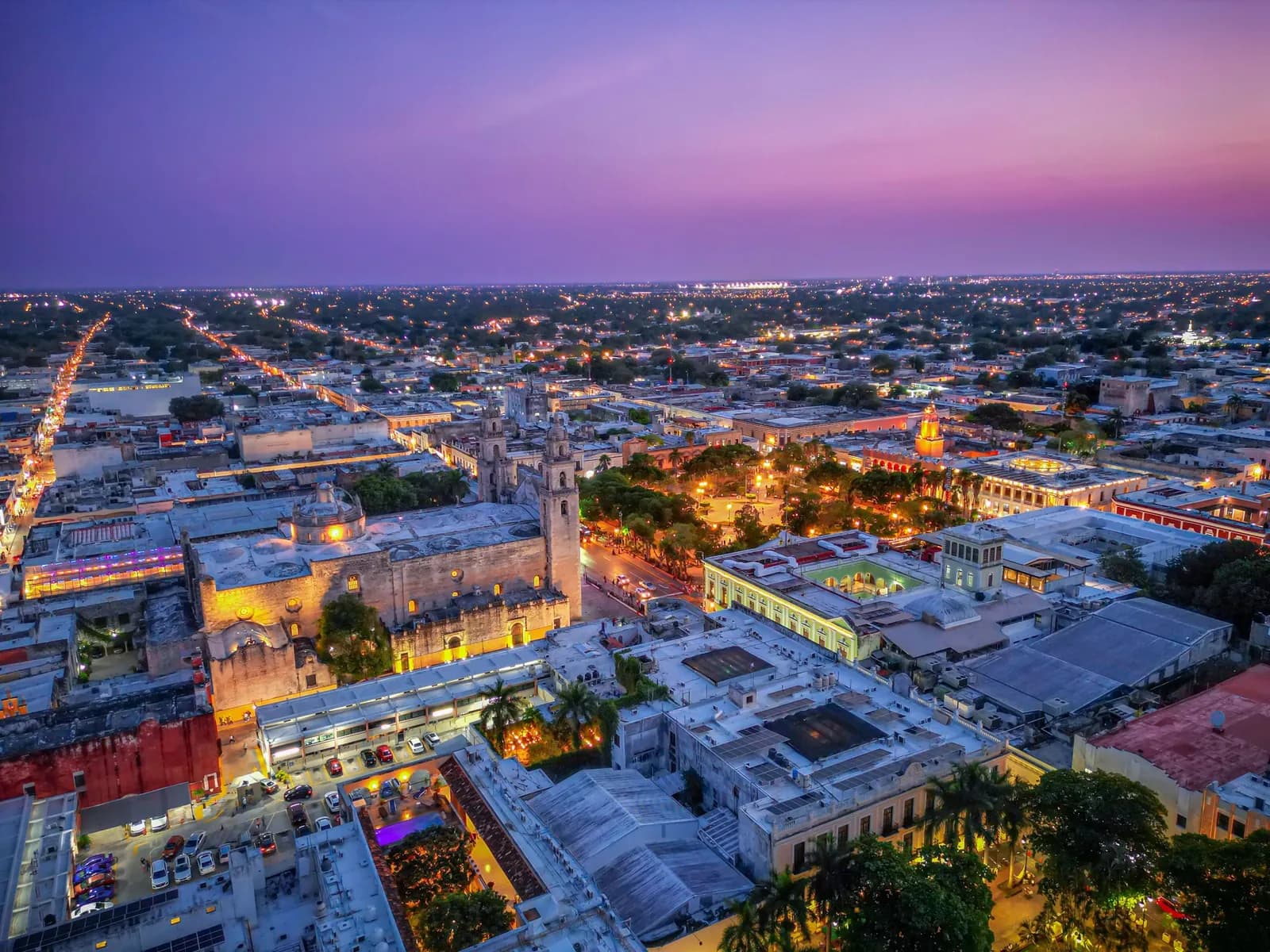 Vista aérea del centro de Mérida al atardecer, con la Catedral y la Plaza Grande